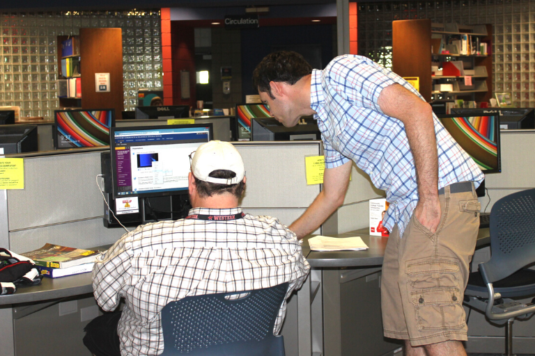 staff helping student in library